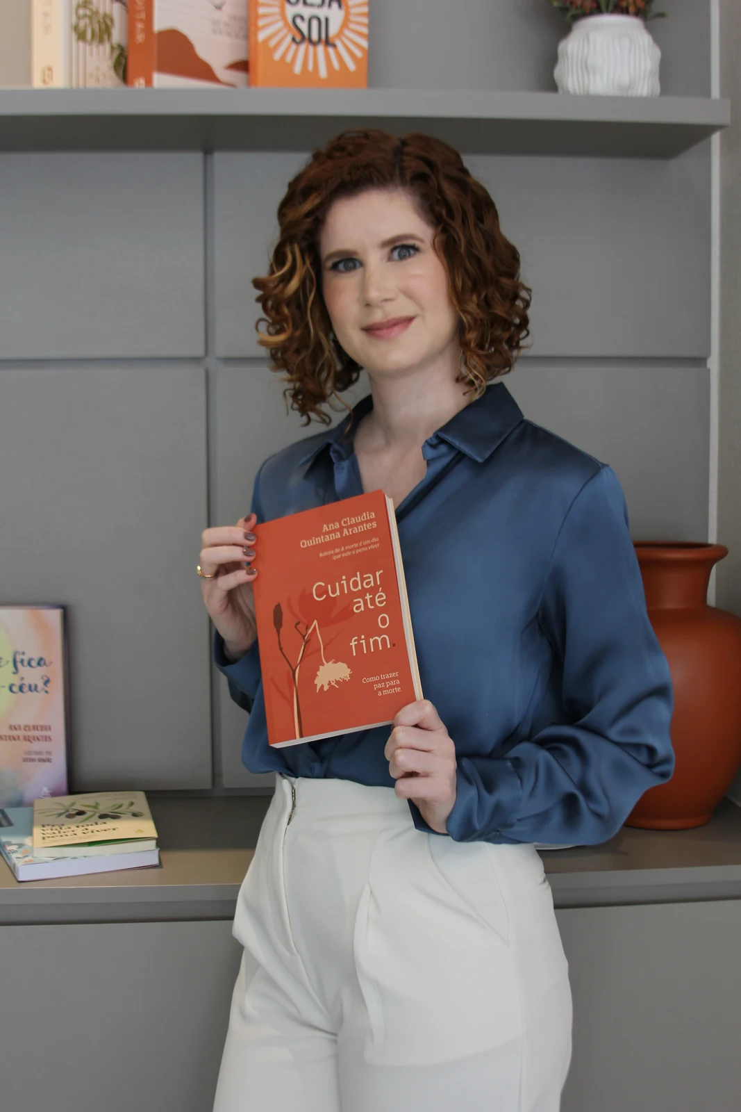 Dra. Karen no consultório, segurando um livro
